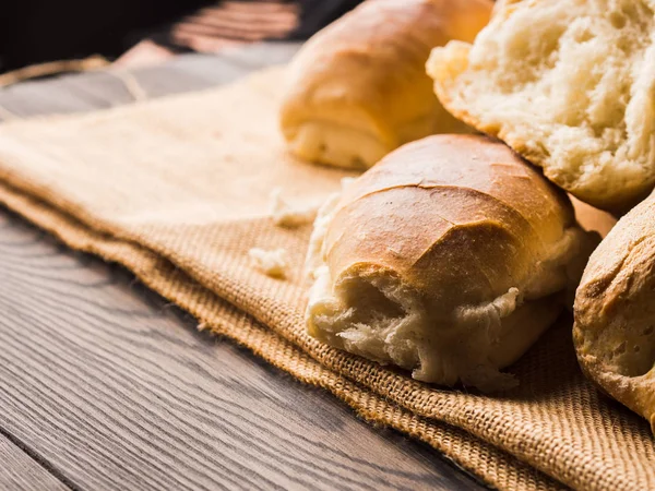 Çuval bezi koyu ahşap arka plan üzerinde taze pişmiş ekmek