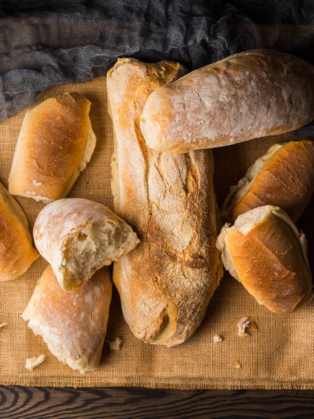 Versgebakken brood op jute donkere houten achtergrond — Stockfoto