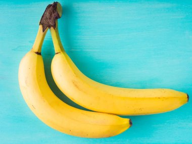 Yeşil pastel üzerinde iki muz