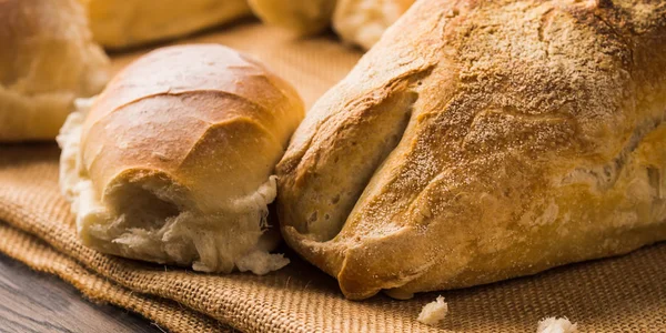 Versgebakken brood op jute donkere houten achtergrond — Stockfoto