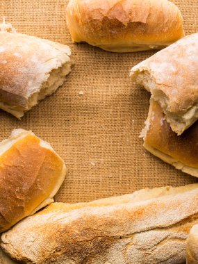 Çuval bezi koyu ahşap arka plan üzerinde taze pişmiş ekmek