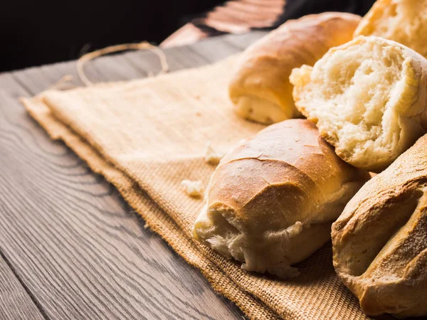 Versgebakken brood op jute donkere houten achtergrond — Stockfoto