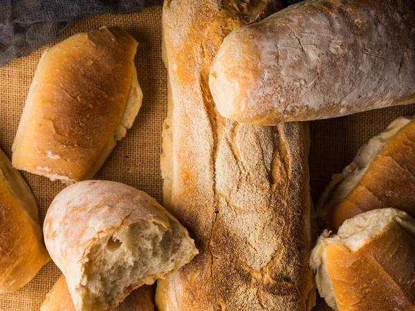 Versgebakken brood op jute donkere houten achtergrond — Stockfoto