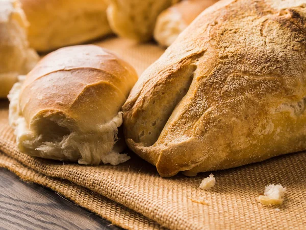 Versgebakken brood op jute donkere houten achtergrond — Stockfoto