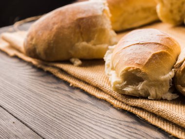 Çuval bezi koyu ahşap arka plan üzerinde taze pişmiş ekmek