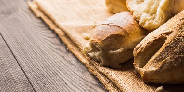 Frisch gebackenes Brot auf dunklem Holzgrund — Stockfoto