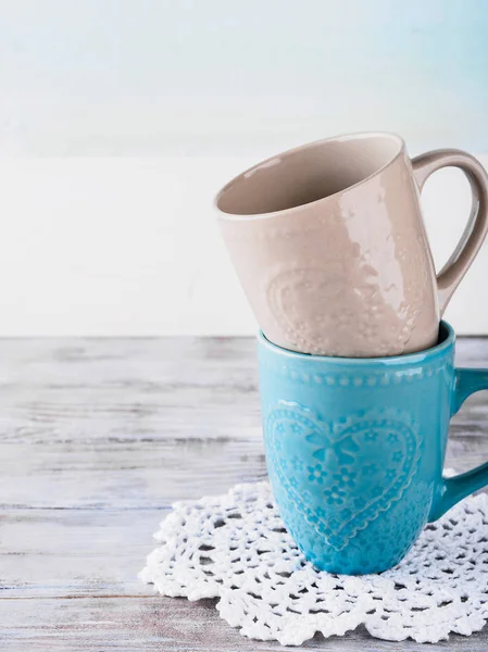 Ahşap arka plan üzerinde yürekleri iki seramik bardak