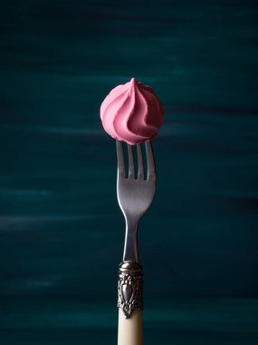 Koyu yeşil çatalı üzerinde pembe beze