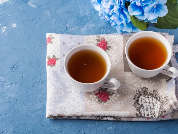 Tasse de thé sur fond bleu avec des fleurs — Photo