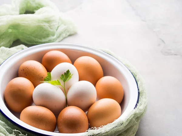 Beyaz ve kahverengi tavuk yumurta bir kapta