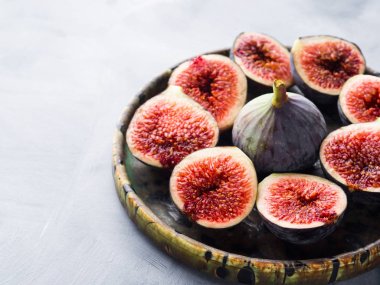 Gri arka plan üzerinde mor incir tabak