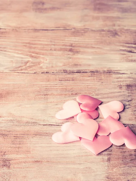 Roze hartjes op getextureerde houten tafel — Stockfoto