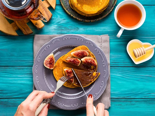 Eating pumpkin pancakes with figs and honey — Stock Photo, Image