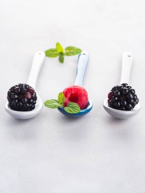 Üzerinde gri arka plan üzerine kaşık taze çilek