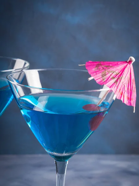 Blauwe cocktail in Martiniglas met paraplu — Stockfoto