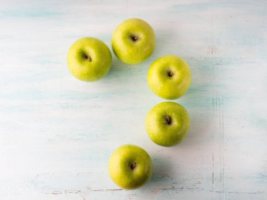 Yeşil elma soru işareti turkuaz beyaz masada