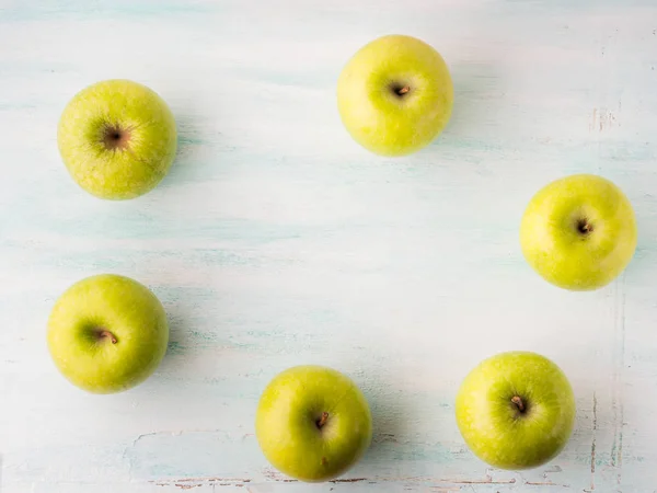 Зеленые яблоки рамка на бирюзовом белом столе — стоковое фото