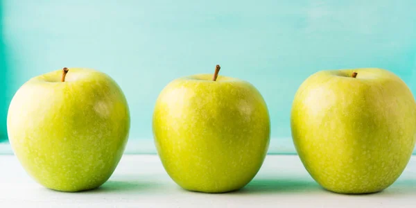 Three Green apples on turquoise background — Stock Photo, Image