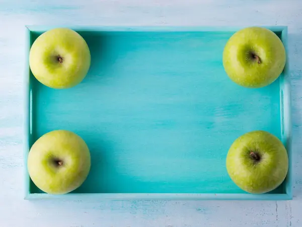 Green apples frame on turquoise tray — Stock Photo, Image