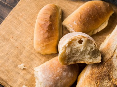 Çuval bezi koyu ahşap arka plan üzerinde taze pişmiş ekmek