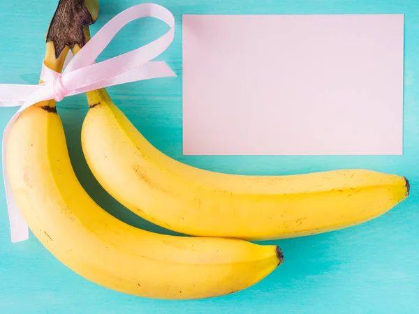 Due banane con nastro rosa e carta — Foto Stock