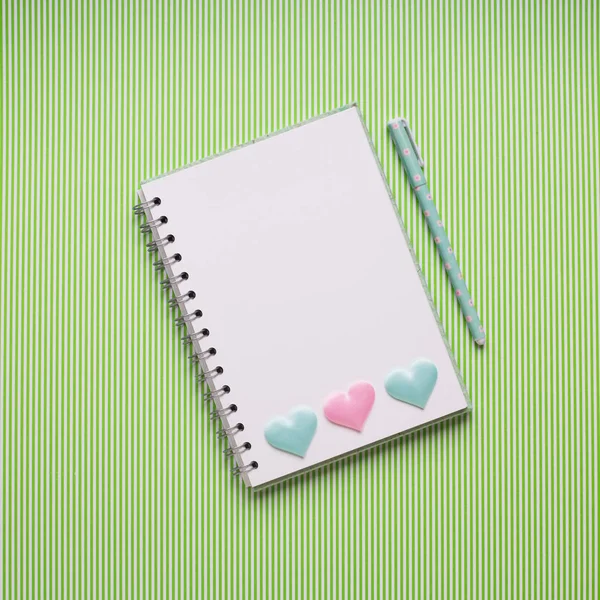 Witte notebook met hart op groen — Stockfoto