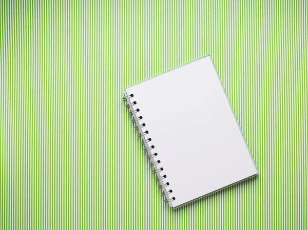 White notebook on striped green background — Stock Photo, Image