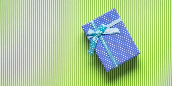 在绿色背景上的蓝色礼品盒 — 图库照片