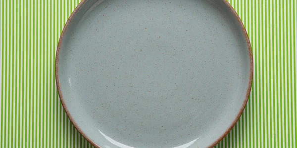 Макет серой тарелки на зеленом фоне — стоковое фото