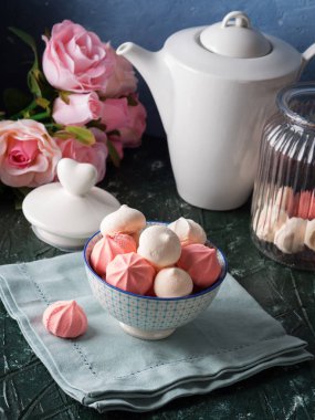 Pembe ve beyaz meringues kase ve çiçekler
