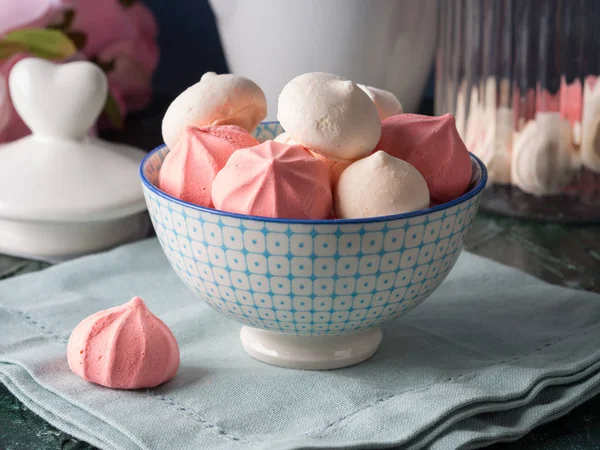 Pink and white meringues in bowl and flowers — Stock Photo, Image