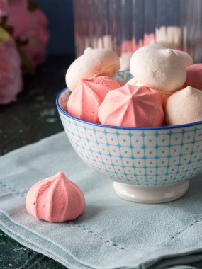 Pembe ve beyaz meringues kase ve çiçekler
