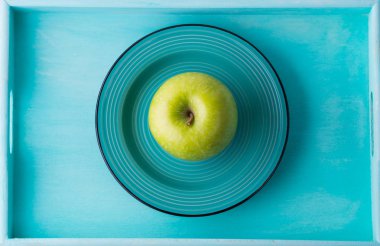 Seramik tabak tepsi içinde yeşil elma