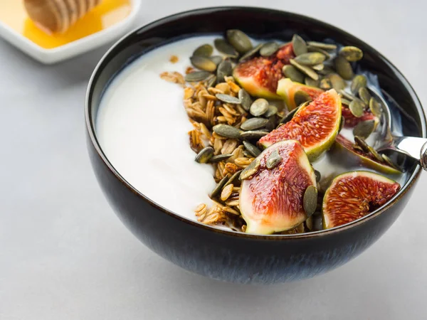 Healthy breakfast yogurt bowl with granola and fig