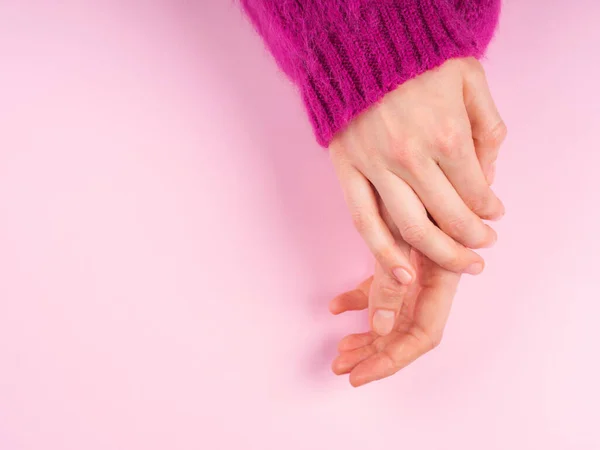 Ženské ruce v purpurovém svetru na růžové — Stock fotografie