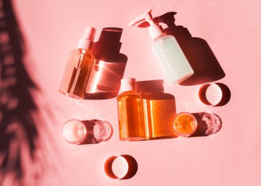 Pembe mercan üzerinde çeşitli kozmetik ürünler. Düz yatıyordu