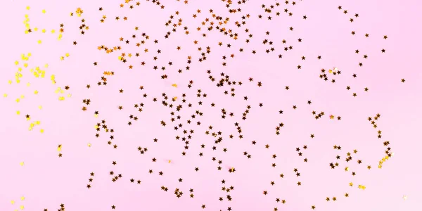 黄金の星のコンフェッティと祭ピンクの背景 — ストック写真
