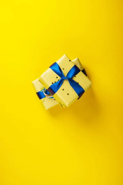 Scatole regalo con nastro blu su colore giallo grassetto — Foto Stock