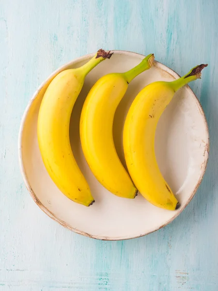 Tre banane su un piatto di turchese verde — Foto Stock