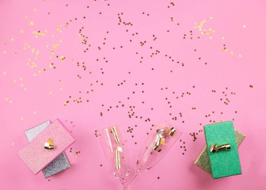 Şampanya kadehleri ve pembe hediyeler. Konfeti