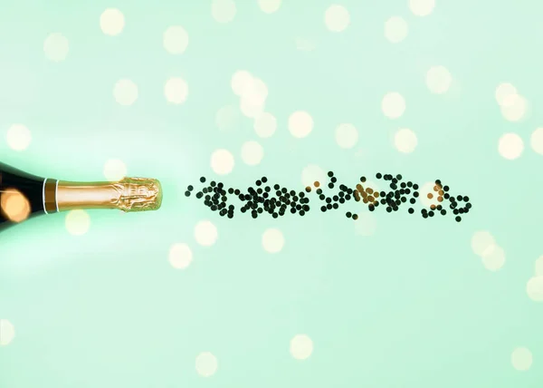 Garrafa de champanhe e fluxo de confetes em aqua verde — Fotografia de Stock