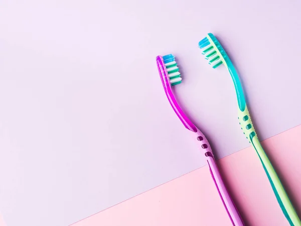 Duas escovas de dentes de um par em rosa pastel — Fotografia de Stock