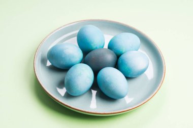 Pastel yeşil arka plan üzerinde mavi paskalya yumurtaları