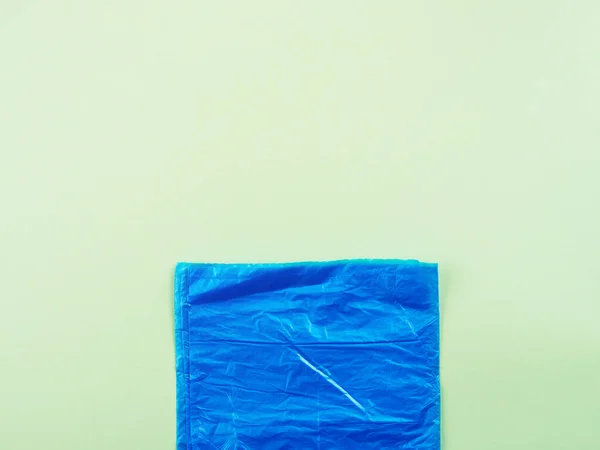 Blue plastic garbage bag roll on green background — 스톡 사진