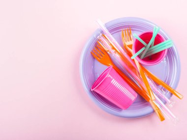 Tek kullanımlık plastik tabak, saman ve cam.