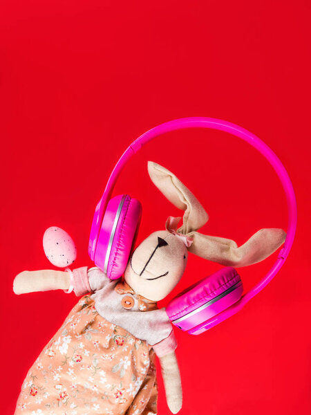 Easter bunny with pink headphones. Holiday concept