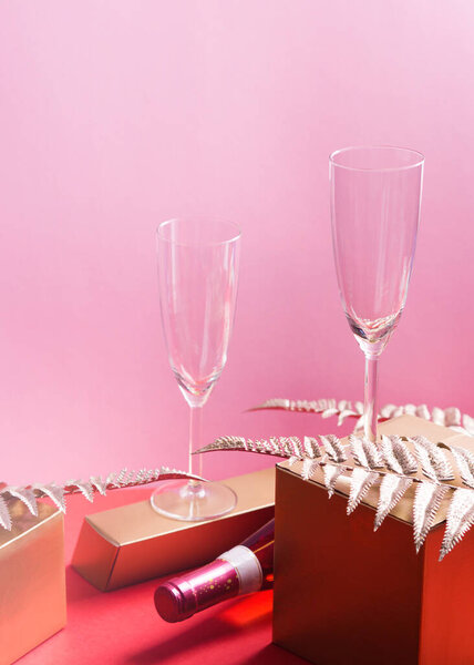 Bottle of rose wine and flutes, golden branches