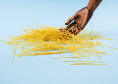 Kırık spagetti mavi üzerine ahşap elle