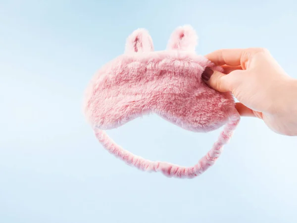 Miękka różowa maska sypialna króliczka z uszami w dłoni — Zdjęcie stockowe
