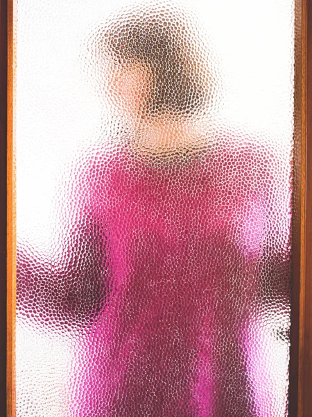 Fiatal nő zárt ajtó mögött, üvegen keresztül — Stock Fotó